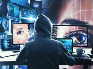 Back view of hacker at desk using computers and hacking face recognition system. Hack and malware concept. Multiexposure